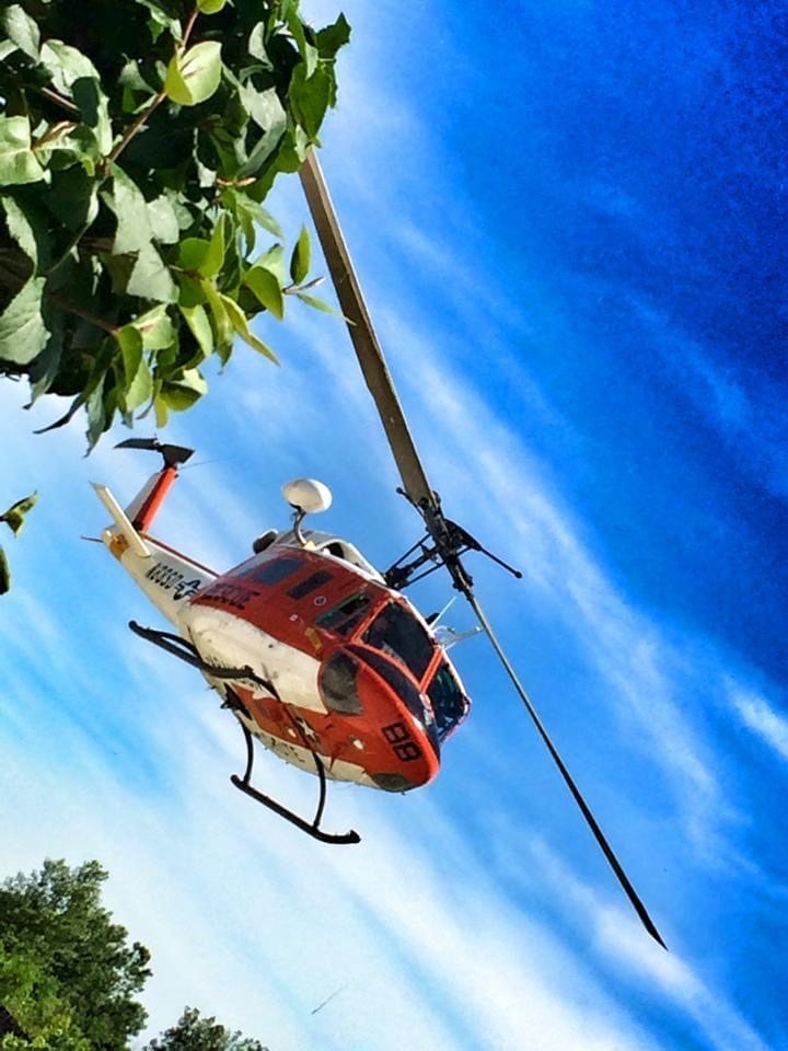 Red and white UH-1 in flight